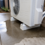 Water pooling around an outdoor reverse cycle air conditioning unit during a normal winter defrost cycle while operating in heating mode.