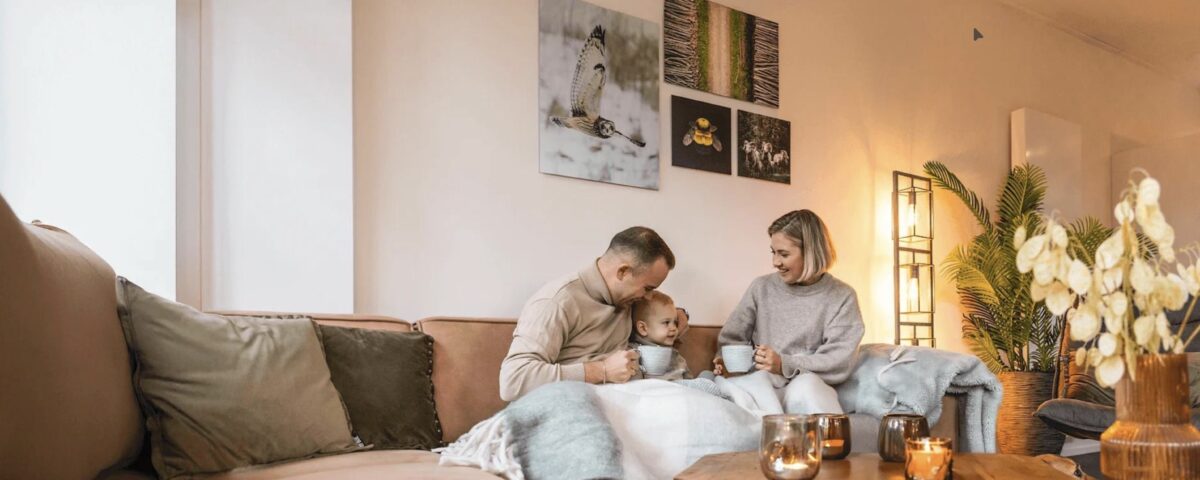 Family relaxing together in a warm, comfortable living room during winter with a reverse cycle heating system keeping the home cosy.