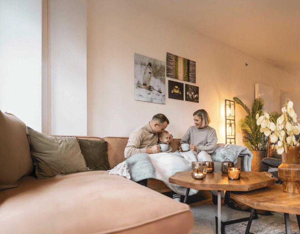 Family relaxing together in a warm, comfortable living room during winter with a reverse cycle heating system keeping the home cosy.