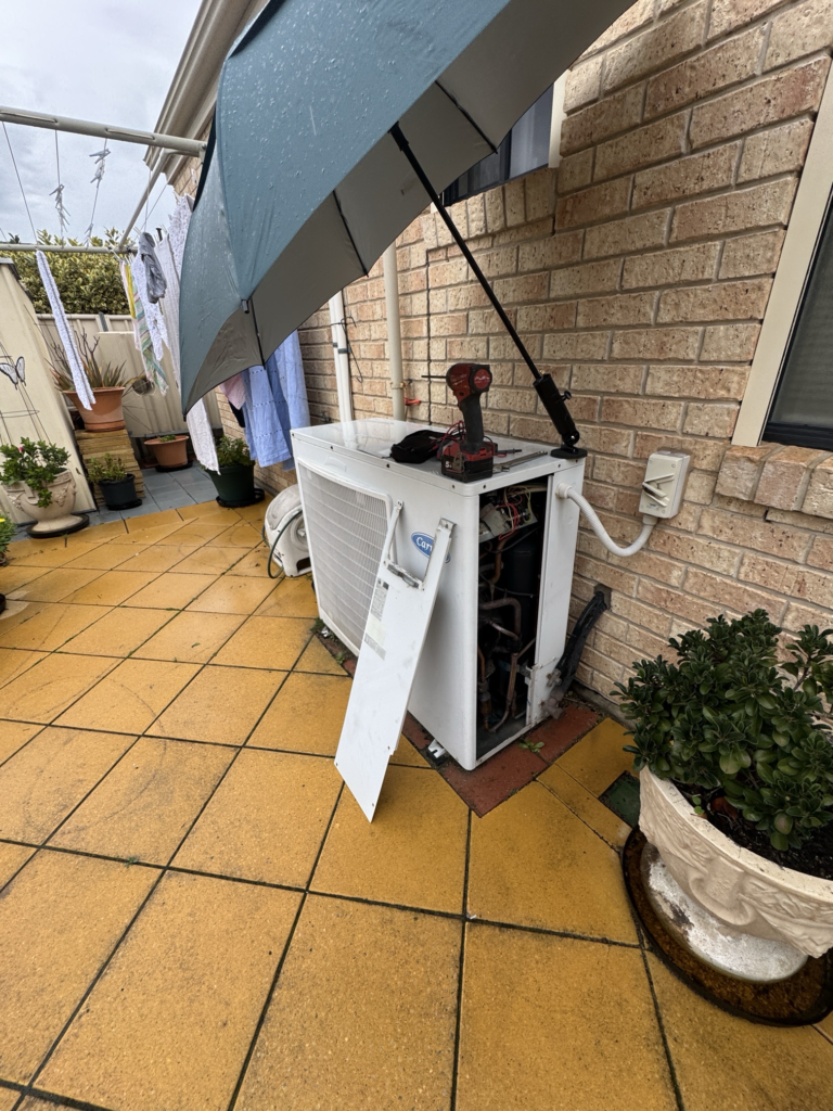 Original 20-year-old Carrier ducted air conditioning outdoor unit at a home in Fulham Gardens before being replaced by a new Panasonic reverse cycle system.